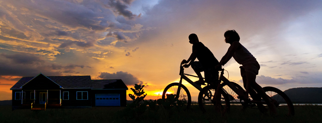 two people riding bikes at sunset in front of a home - Vacation Home, Second Home, Recreation, Active Adult - Bill Salvatore, Realty Excellence East Valley - Arizona Elite Properties