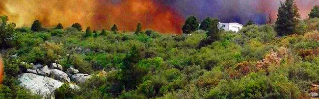 Wildfire approaching a home - HOA Wildfire Mitigation Policy
