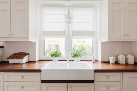 White, farmhouse sink in a wood kitchen countertop