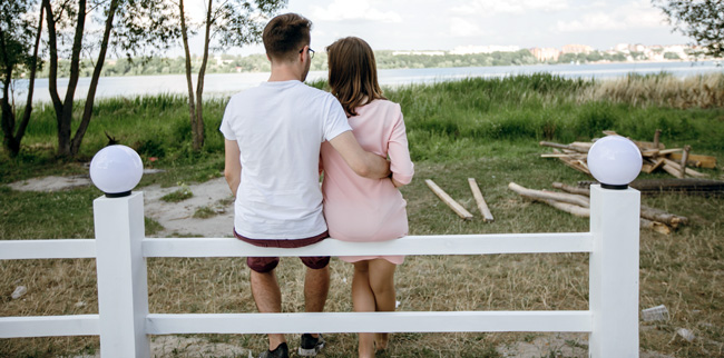 a young couple sitting on a white rail fence - Sellers Market, Market Conditions, Mortgage Interest Rates - Bill Salvatore, Arizona Elite Properties 602-999-0952 - Arizona Real Estate