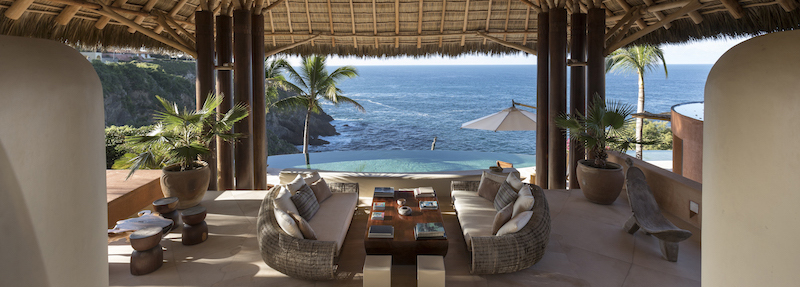 Pacific Ocean view from inside a thatched roof cabana, with dining table and chairs - Luxury Homes, Landscaping, Ocean View,courtesy of RIS Meadia, Gorgeous Grounds - Bill Salvatore, Your Valley Property Team - Arizona Elite Properties 602-999-0952