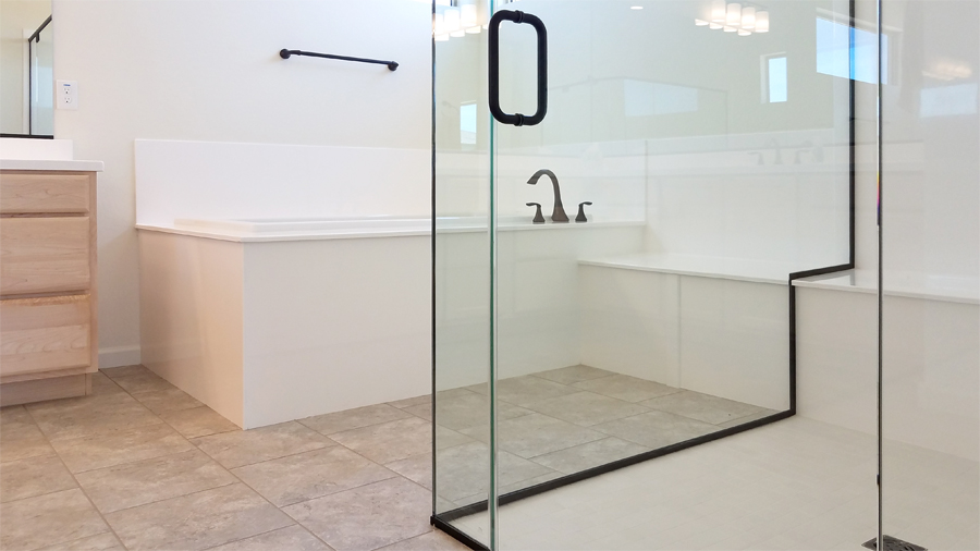large bathroom with gray tile floor, white modern bathtub and glass walk-in shower - Separate tub and shower - Trilogy at Wickenburg Ranch - Home for Sale, 4023 Miners Gulch Way, Wickenburg AZ - Bill Salvatore, Your Valley Property Team - Arizona Elite Properties 602-999-0952