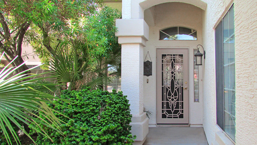 front door with archway and ceiling, iron security door and bushes to left - Welcoming covered entrance - 457 S Marina Dr, Gilbert AZ - The Islands - Bill Salvatore, Your Valley Property Team - Arizona Elite Properties 602-999-0952