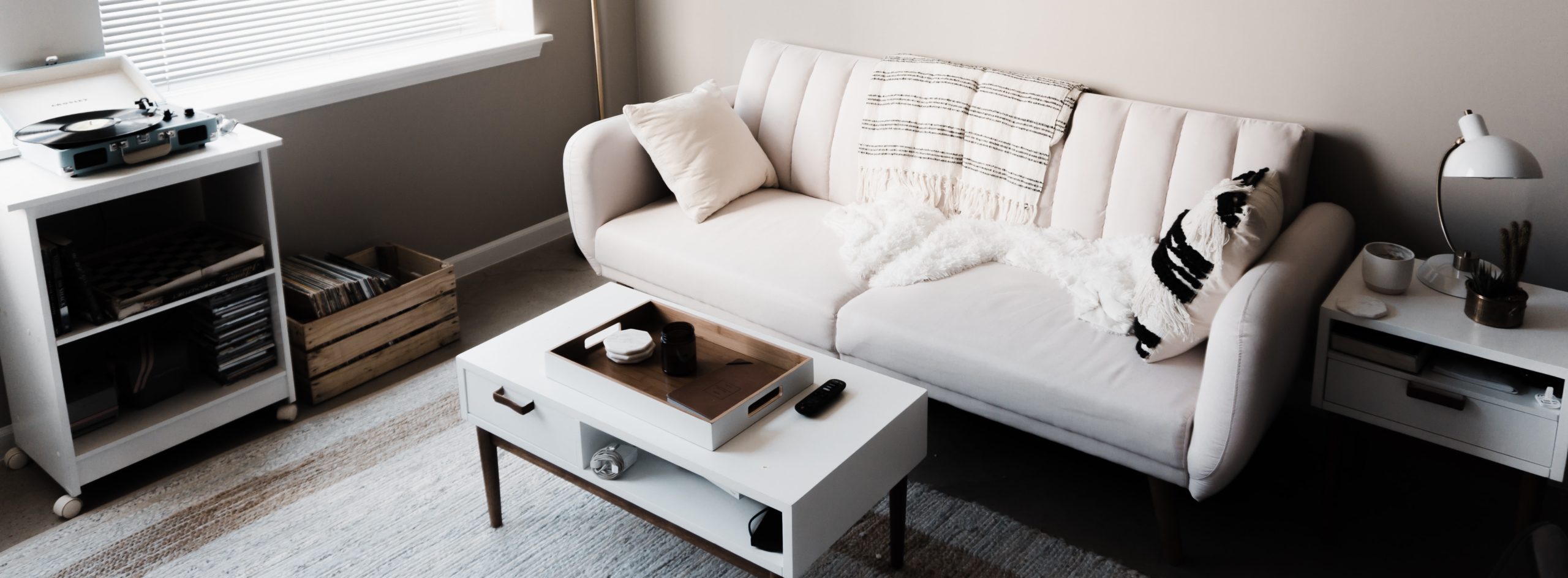 White sofa and coffee table on simple gray rug, gray walls - Minimal Design - Low Maintenance Home - ian-dooley-_-JR5TxKNSo-unsplash - Bill Salvatore, Your Valley Property Team - Arizona Elite Properties 602-999-0952