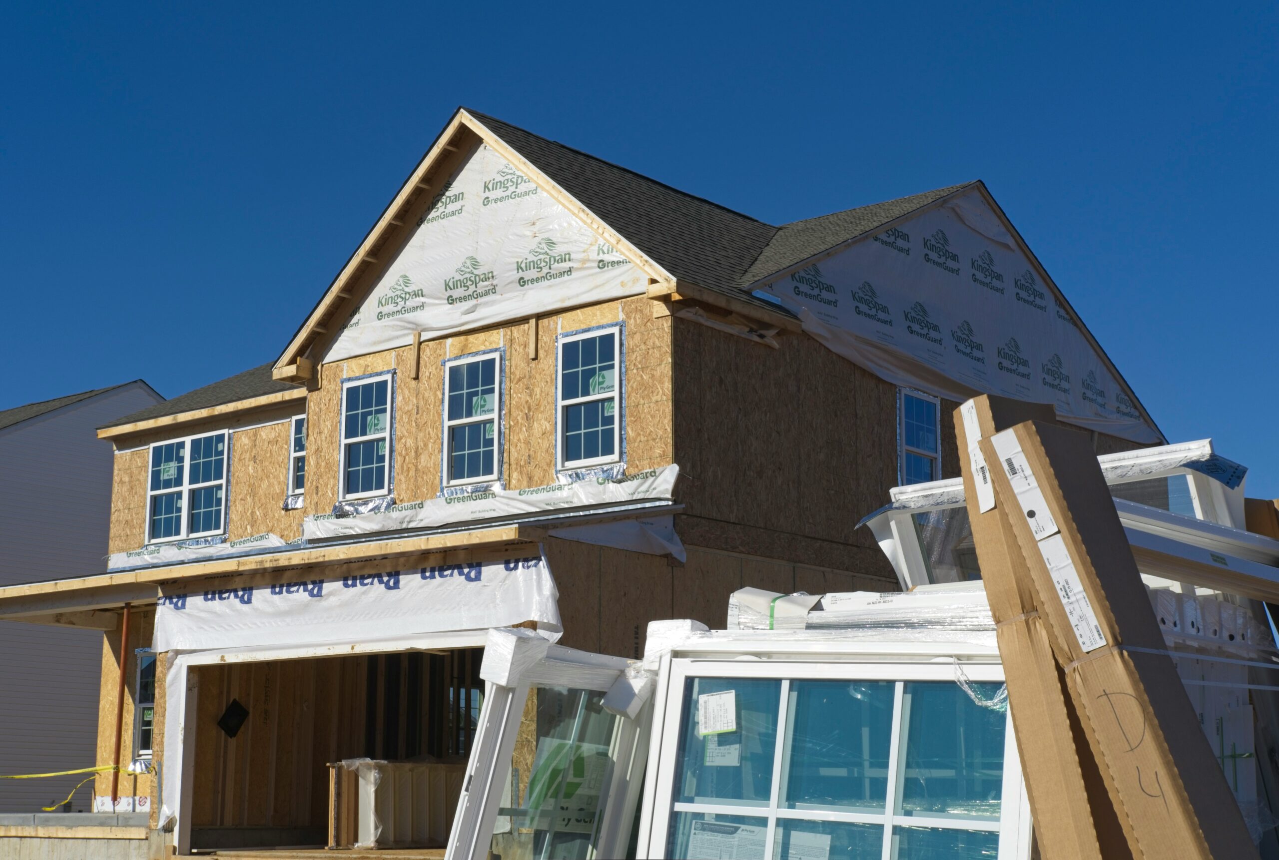 partially build home with windows and other construction elements in front